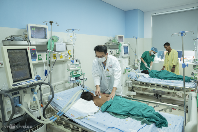 Bác sĩ Trần Long Quân thăm khám cho hai bệnh nhi, sáng 12/3. Ảnh: Nguyễn Đông