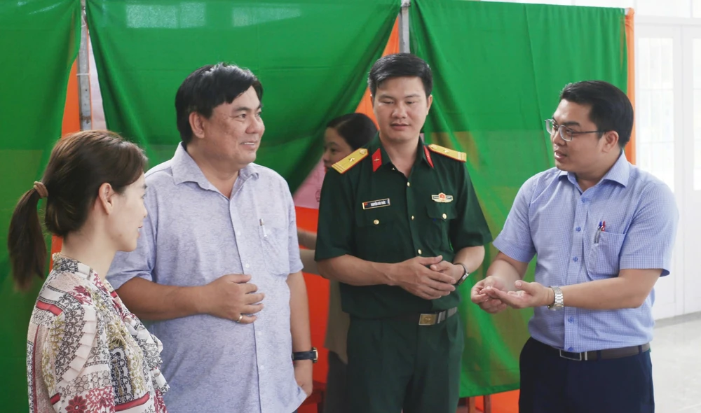 Lãnh đạo địa phương kiểm tra công tác chuẩn bị tại điểm bầu cử. Ảnh: VIỆT ĐỨC