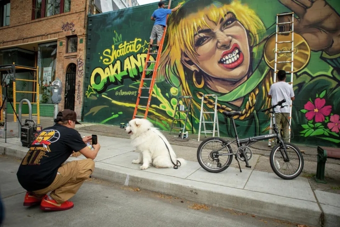 Các họa sĩ thuộc nhóm Illuminaries vẽ bức tranh tường tôn vinh nhà vô địch Olympic trượt băng nghệ thuật Alysa Liu trên đại lộ Telegraph ở Oakland, bang California, Mỹ ngày 28/2/2026. Ảnh: S.F. Chronicle