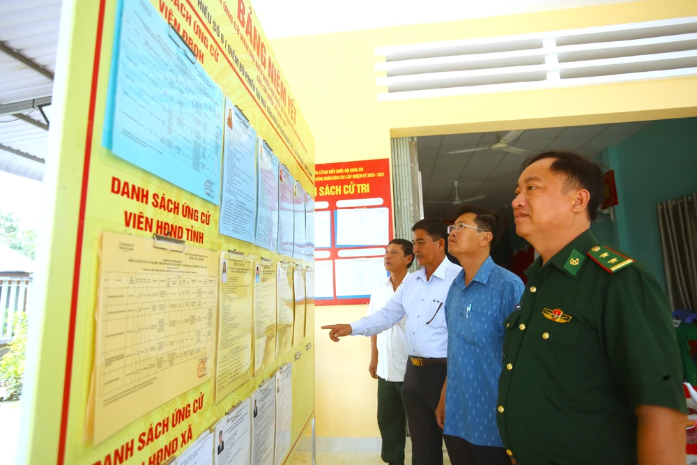 Ông Nguyễn Hữu Trọng, Chủ tịch UBND xã Bình Hiệp (áo xanh) kiểm tra tại khu vực bầu cử số 6. Ảnh: HUỲNH DU bầu cử 6.JPG