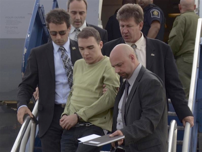 Luka Magnotta bị cảnh sát Montreal áp giải xuống máy bay từ Đức tại Mirabel, ngày 18/6/2012. Ảnh: Reuters
