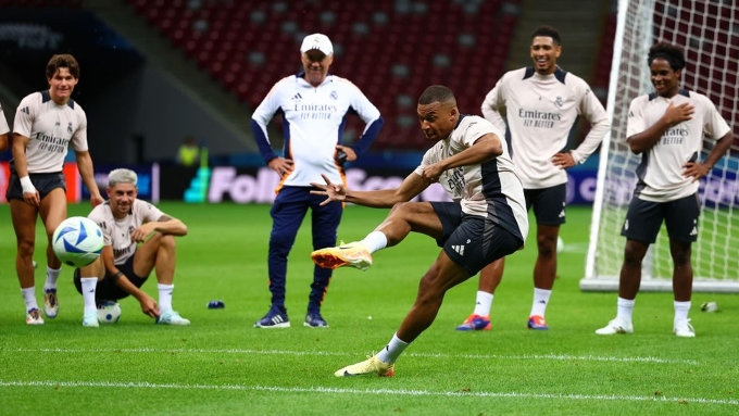 Ancelotti (áo trắng) dõi theo một cú dứt điểm của Mbappe trong buổi tập cùng Real Madrid năm 2025. Ảnh: AFP