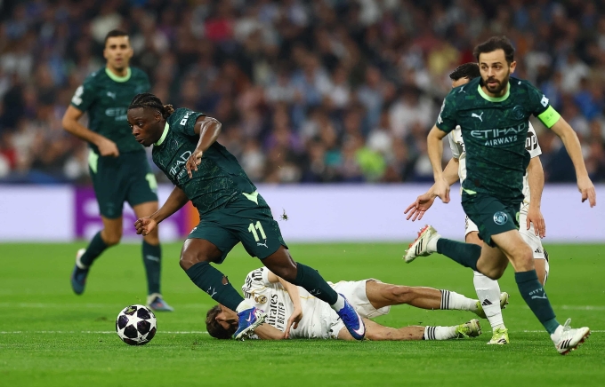 Man City áp đảo ở đầu trận với tốc độ của Doku (số 11) và những cầu thủ giàu kỹ thuật như Bernardo Silva (phải). Ảnh: Reuters