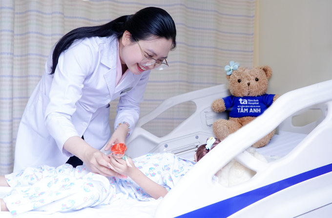 Bác sĩ Thủy kiểm tra sức khỏe, tặng quà cho An trước khi xuất viện. Ảnh: Ngọc Châu