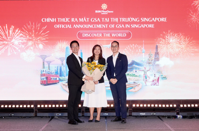 Đại diện tổng đại lý Discover the World tại thị trường Singapore (giữa) nhận hoa tri ân từ Sun PhuQuoc Airways. Ảnh: SPA