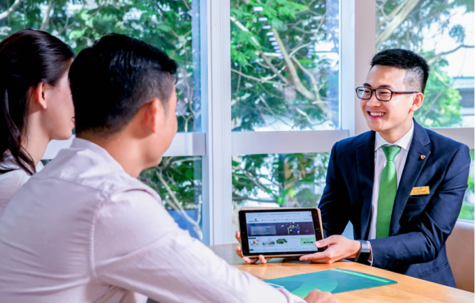 Nhân viên Vietcombank hướng dẫn dịch vụ cho khách hàng. Ảnh: Vietcombank