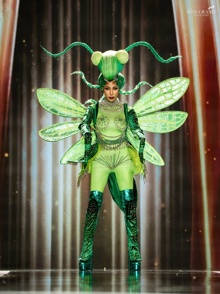 Thí sinh xiếc khỉ, trườn bò trên sân khấu Hoa hậu Hòa bình 9 Đại diện tỉnh Surin trình diễn thiết kế mang tên Oh-Ka-Nob-Ting-Tong - một điệu múa dân gian truyền thống của vùng Isaan phía Nam, Surin, được lưu truyền hơn 50 năm. Điệu múa mô phỏng chuyển động của bọ ngựa trong mùa thu hoạch.