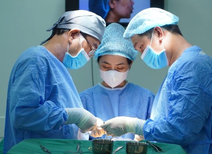 Bác sĩ Lê Viết Trí (bên trái) và êkíp phẫu thuật cho bệnh nhân. Ảnh: Bệnh viện cung cấp