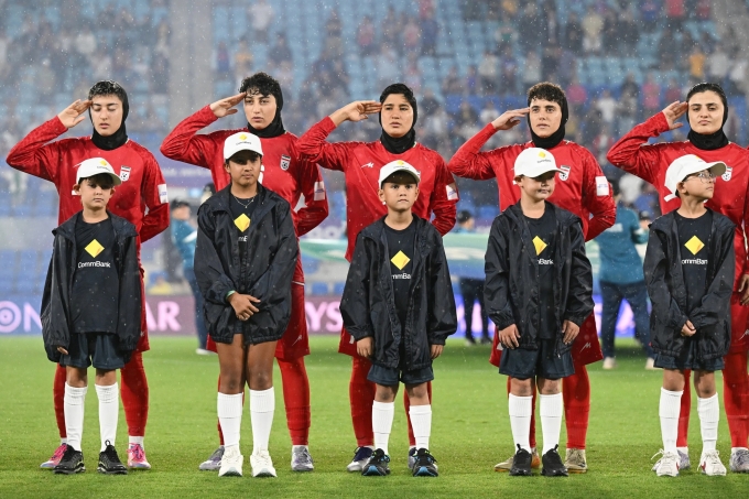 Đội nữ Iran chào cờ và hát quốc ca trước trận gặp Philippines ở lượt cuối bảng A Asian Cup nữ 2026, trên sân Gold Coast, bang Queensland, Australia tối 8/3/2026. Ảnh: AP