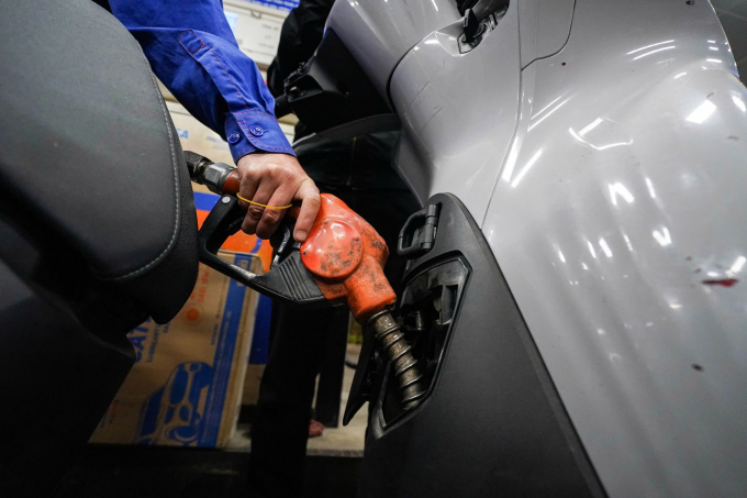 Nhân viên một cửa hàng ở đường Láng, Hà Nội bơm xăng cho khách hàng, ngày 11/3. Ảnh: Hoàng Giang