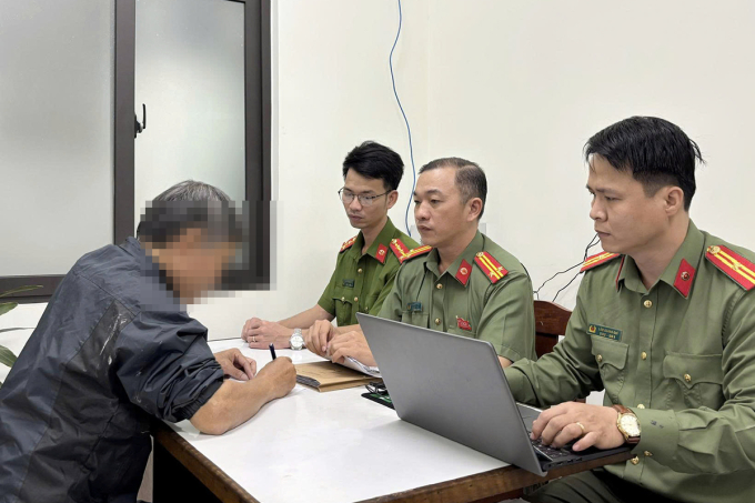 Công an làm việc với người đàn ông chia sẻ thông tin xuyên tạc từ các fanpage chống phá Nhà nước. Ảnh: Công an cung cấp