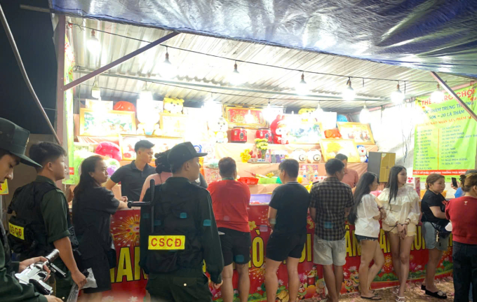 Cảnh sát ập vào kiểm tra gian hàng bốc thăm trúng thưởng. Ảnh: Nam An