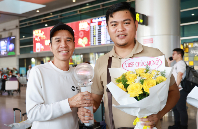 Hai cơ thủ Trần Quyết Chiến (trái) và Nguyễn Trần Thanh Tự bên Cup vô địch giải billiards carom 3 băng đồng đội thế giới, tại sân bay Tân Sơn Nhất, chiều 3/3. Ảnh: Đức Đồng