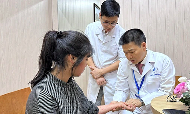 PGS Lê Hữu Doanh thăm khám cho một bệnh nhân vảy nến. Ảnh: Minh Đức