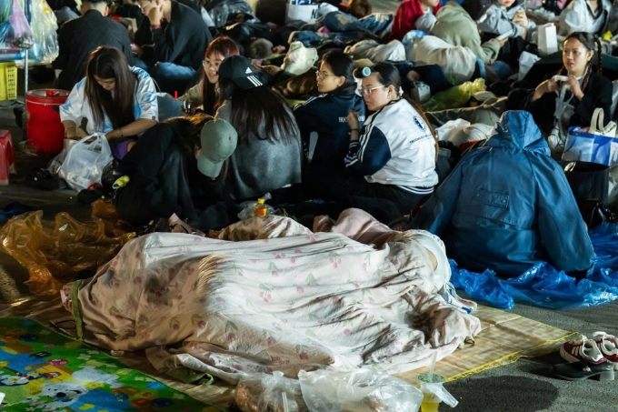 Fan ngủ tại vị trí xếp hàng, chờ đến giờ check in. Ảnh: Tùng Đinh