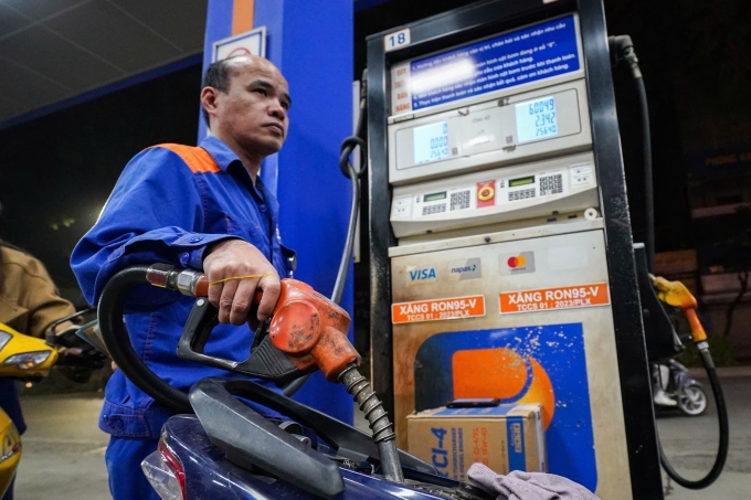 Nhân viên một cửa hàng ở đường Láng, Hà Nội bơm xăng cho khách hàng, ngày 11/3. Ảnh: Hoàng Giang