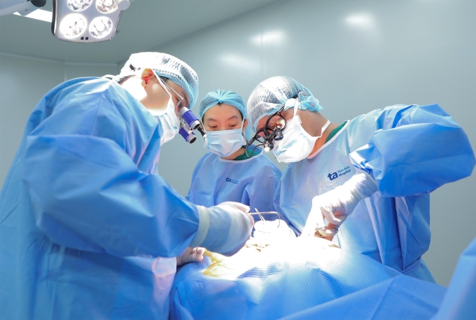 Bác sĩ Khang (ngoài cùng bên phải) cùng êkíp phẫu thuật cho bệnh nhân. Ảnh: Trung Vũ