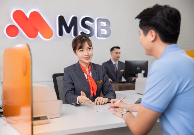 Giao dịch viên hỗ trợ khách hàng làm thủ tục tại quầy. Ảnh: MSB