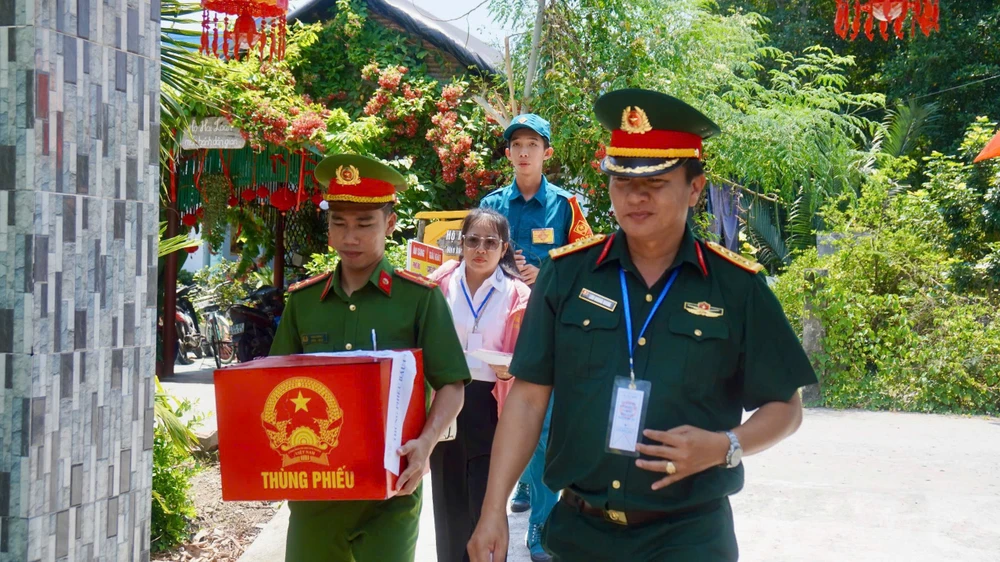 Tổ bầu cử số 04 tại trụ sở ấp Thiềng Liềng, xã Thạnh An mang thùng phiếu phụ đến nhà các cụ già gặp khó khăn trong việc đi lại. Ảnh: SONG MAI khong-de-ai-lo-ngay-bau-cu-mang-thung-phieu-den-tan-nha-cu-tri-lon-tuoi-o-thieng-lieng-can-gio-5.jpg