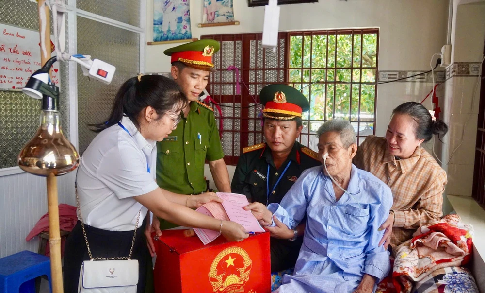 Ông Nguyễn Văn Thanh (cử tri ấp Thiềng Liềng) dù bị bệnh và đang nằm một chỗ nhưng vẫn được tổ bầu cử hỗ trợ, mang thùng phiếu đến nhà để ông tự tay bỏ lá phiếu tín nhiệm của mình. Ảnh: SONG MAI cu-tri.jpg