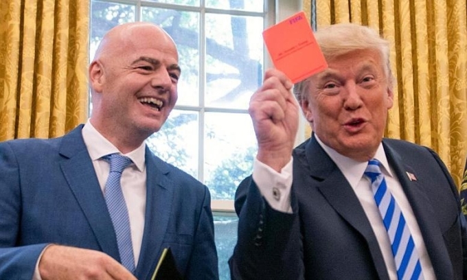 Tổng thống Mỹ Donald Trump giơ thẻ đỏ về phía báo chí sau khi Chủ tịch FIFA Gianni Infantino tặng ông một bộ thẻ trọng tài trong cuộc gặp tại Phòng Bầu dục, Nhà Trắng ở Washington, D.C., Mỹ, ngày 28/8/2018. Ảnh:� EFE