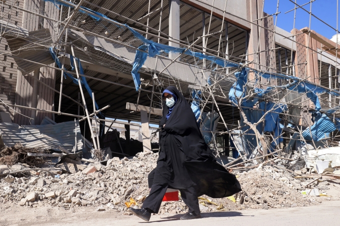 Người phụ nữ đi qua một công trình bị phá hủy gần quảng trường Ferdowsi ở Tehran ngày 3/3. Ảnh: AFP