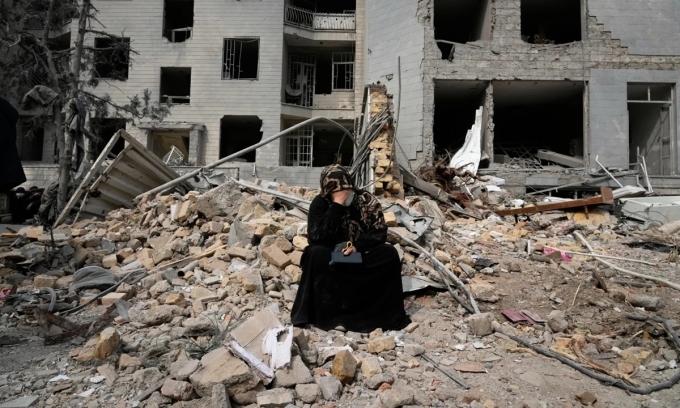 Người phụ nữ ngồi giữa đống đổ nát của một tòa nhà dân cư ở thủ đô Tehran, Iran, sau cuộc không kích từ Mỹ - Israel hôm 12/3. Ảnh: AP