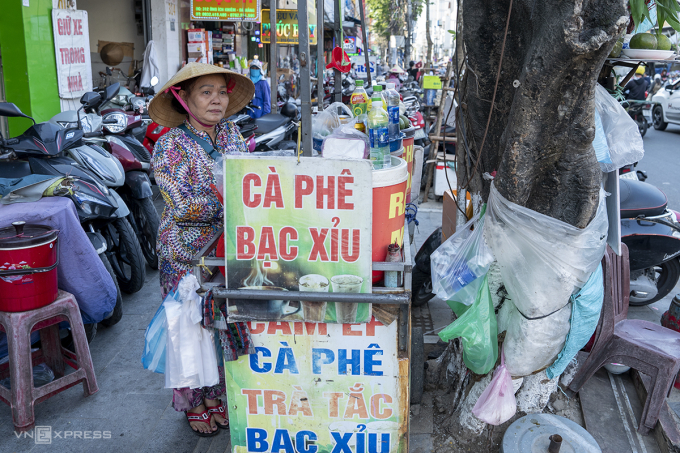 Bà Lê Thị Sự dọn quầy bán nước giải khát mang đi vào gốc cây bồ đề trên đường Ông Ích Khiêm, nhưng xung quanh vỉa hè vẫn ngổn ngang vì xe máy của các hộ kinh doanh mặt tiền để lộn xộn. Ảnh: Nguyễn Đông