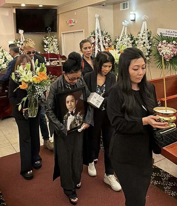 Mẹ Kasim Hoàng Vũ ôm di ảnh con trai khi di quan đến phòng hỏa thiêu. Ảnh: Vy Uyên