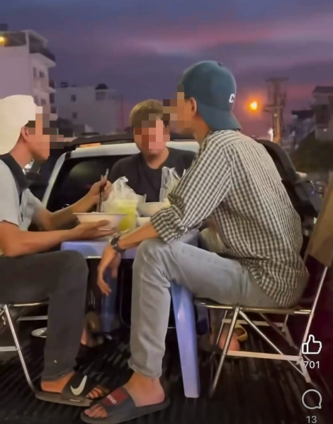 Nhóm người bày bàn ghế, ngồi ăn trên thùng xe bán tải đang chạy ở TP.HCM  - Ảnh 1.