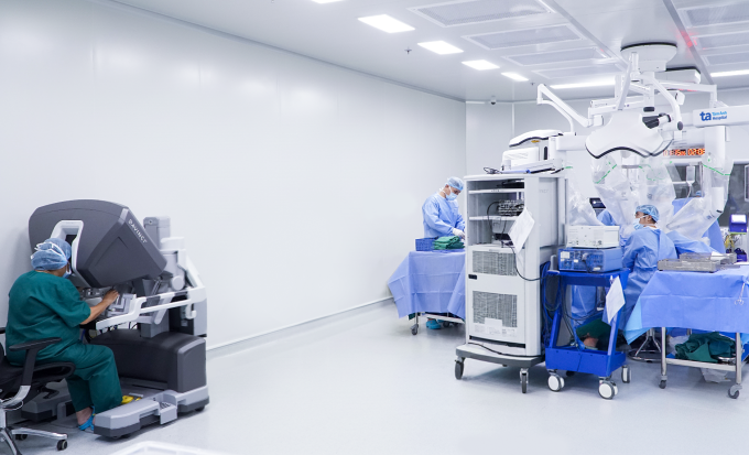 Bác sĩ Nhi (ngồi) điều khiển robot Da Vinci Xi phẫu thuật cho bệnh nhân. Ảnh: Bệnh viện Đa khoa Tâm Anh