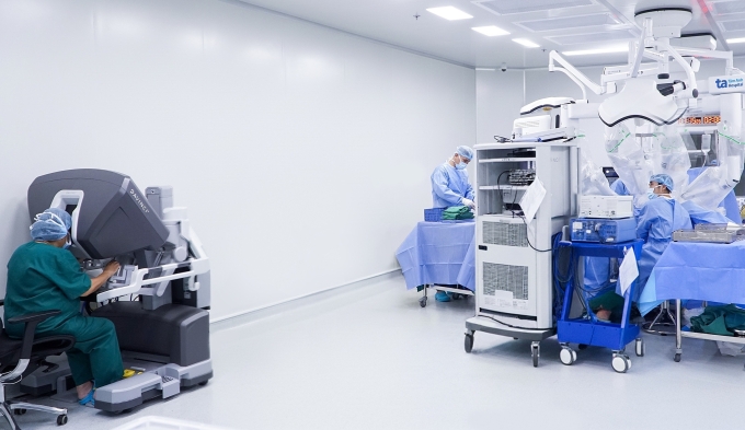 Bác sĩ Mỹ Nhi (ngồi buồng điều khiển) cùng ê kíp sử dụng Robot Da Vinci Xi phẫu thuật cắt tử cung cho bà Mãn. Ảnh: Bệnh viện Đa khoa Tâm Anh