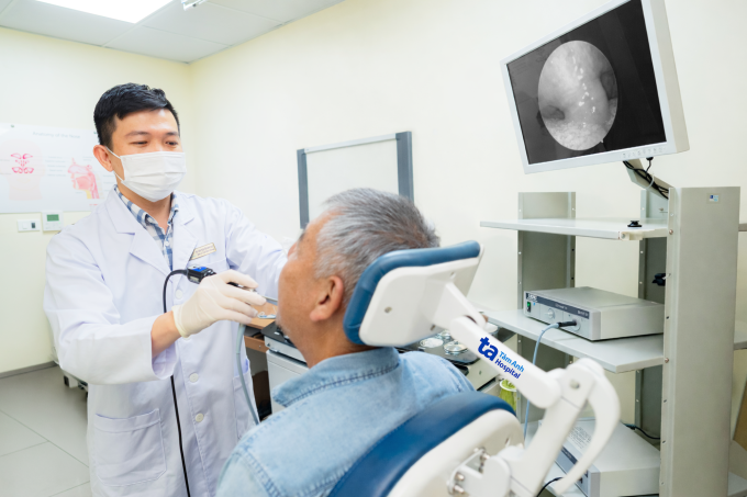 Bác sĩ Như Duy đang nội soi họng cho ông Văn khi tái khám. Ảnh: Bệnh viện Đa khoa Tâm Anh