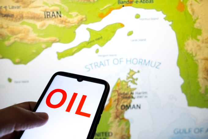 Ảnh chụp từ dầu trên màn hình điện thoại và bản đồ hiển thị eo biển Hormuz: Ảnh: AFP