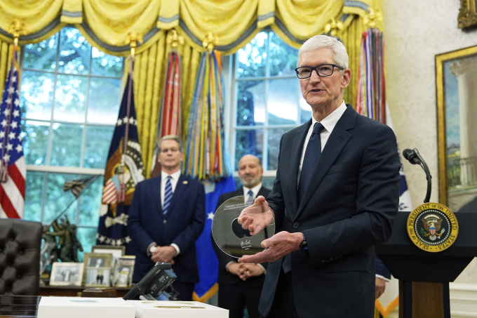 Tim Cook, CEO Apple, cầm món quà từ Tổng thống Mỹ Donald Trump trong một buổi công bố về Apple tại Phòng Bầu dục, Washington, ngày 6/8/2025. Ảnh: AP