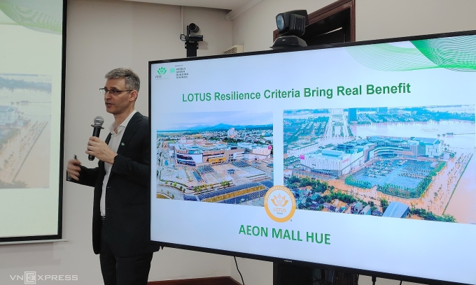 Ông Douglas Snyder, Giám đốc điều hành VGBC, so sánh hai bức ảnh Aeon Mall trước xây dựng và trong lũ lụt. Ảnh: Thủy Trương