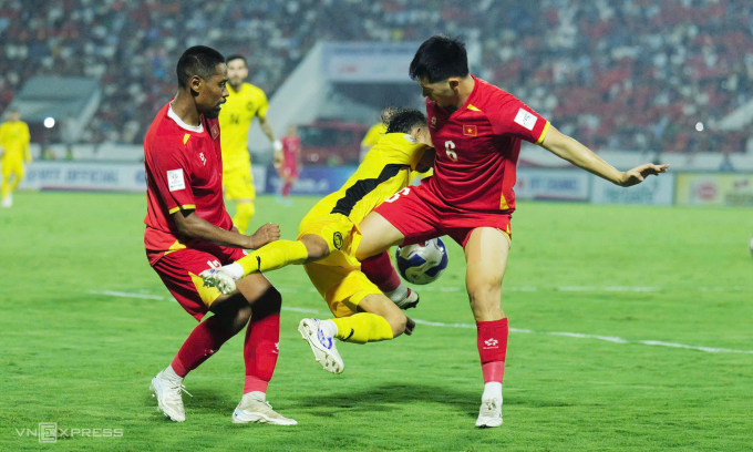 Cao Quang Vinh (trái) và Trần Đình Trọng tranh bóng với Faisal Halim trong trận Việt Nam gặp Malaysia trên sân Thiên Trường. Ảnh: Ngọc Thành