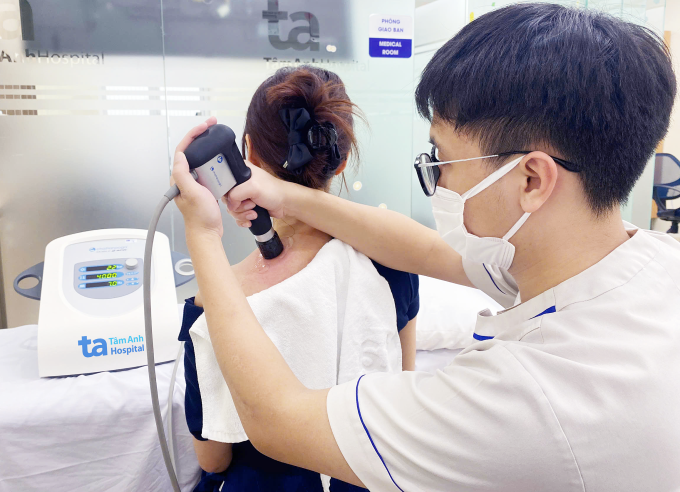Trị liệu với máy phát sóng xung kích giúp nhân viên văn phòng giảm mỏi nhức vai gáy. Ảnh: Bệnh viện Đa khoa Tâm Anh