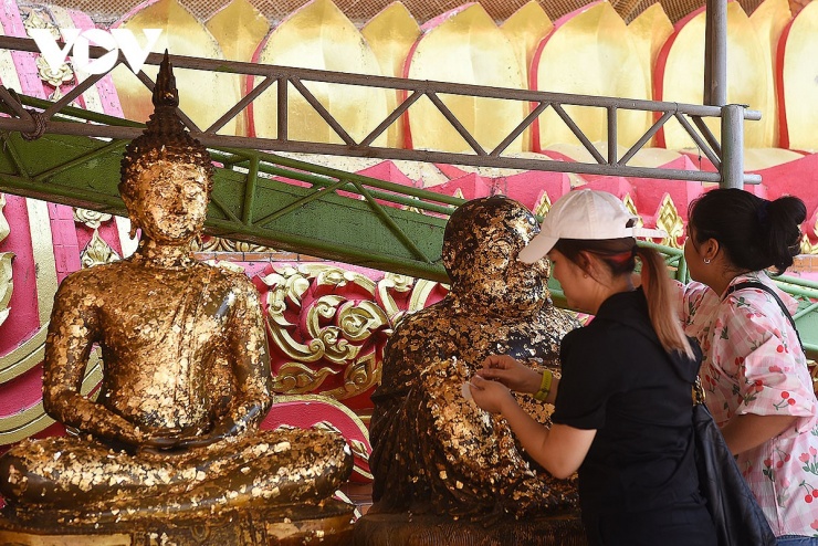 Người dân đến lễ chùa Wat Tham Suea thường mua vàng quỳ dán lên các bức tượng Phật trong chùa.