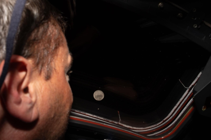 Phi hành gia Reid Wiseman, chỉ huy nhiệm vụ Artemis II, nhìn ra ngoài cửa sổ tàu Orion, ngắm nhìn Mặt Trăng trước chuyến bay qua sát Mặt Trăng. Ảnh: NASA