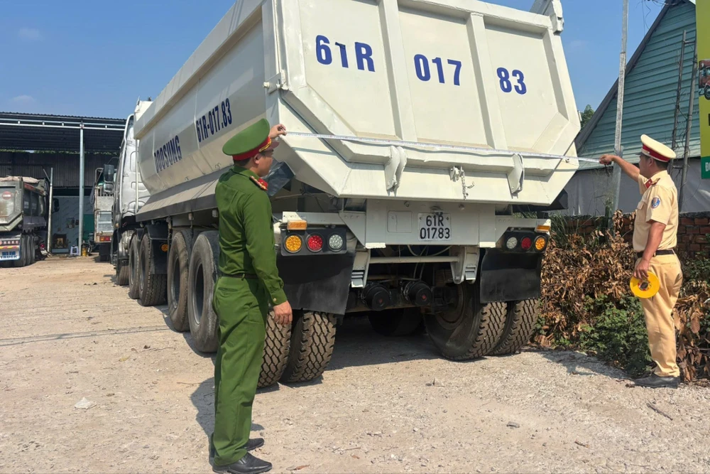 Lực lượng CSGT TP.HCM kiểm tra thực tế xe tải tự đổ, đo đạc kích thước thùng xe, đối chiếu dữ liệu đăng kiểm nhằm phát hiện vi phạm cơi nới, hoán cải trái quy định. Ảnh: PC08 z7702804150357_6db1779c04441b7d0d1f011876324cd3.jpg