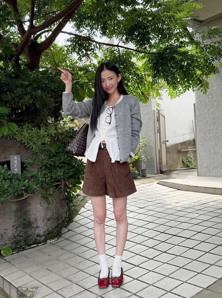 Sơ mi cộc tay đi kèm cardigan, quần shorts nhung và giày búp bê. Cách mặc này phù hợp những ngày giao mùa, thời tiết nóng lạnh thất thường.