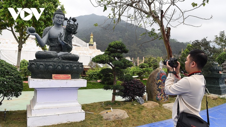 Du khách chụp ảnh một bức tượng trước tháp trung tâm.