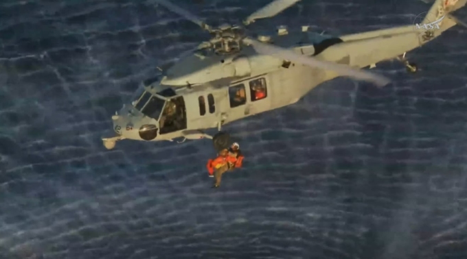 Phi hành gia NASA Reid Wiseman, chỉ huy nhiệm vụ Artemis II, được đưa lên trực thăng quân sự của Mỹ để được vận chuyển đến tàu USS John P. Murtha. Ảnh: NASA