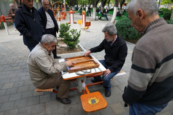 Ali Asghar Nasrulahi, 66 tuổi, bên trái, cựu chiến binh trong cuộc chiến tranh Iran-Iraq, đang chơi cờ backgammon với bạn trong công viên công cộng ở Tehran, ngày 8/4. Ảnh: AP