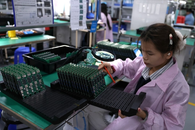 Nhân viên kiểm tra bảng mạch tại một nhà máy đối tác của Agilian Technology ở Đông Quản. Ảnh: Reuters