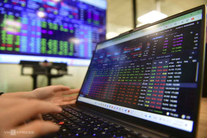 Nhà đầu tư theo dõi bảng giá chứng khoán tại một công ty ở TP HCM. Ảnh: Thanh Tùng