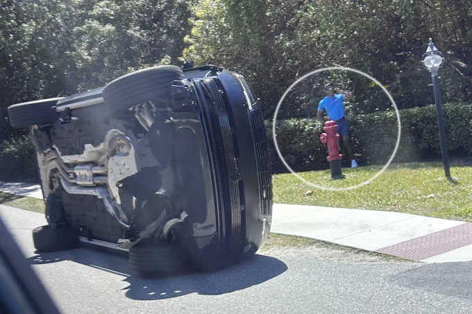 Woods đứng cạnh chiếc xe bị lật của mình ở Florida hôm 27/3. Ảnh: AP