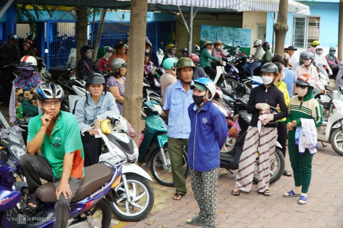 Phụ huynh đợi đón con ở trường Tiểu học Bình Quới Tây, trưa 10/4. Ảnh: Lệ Nguyễn