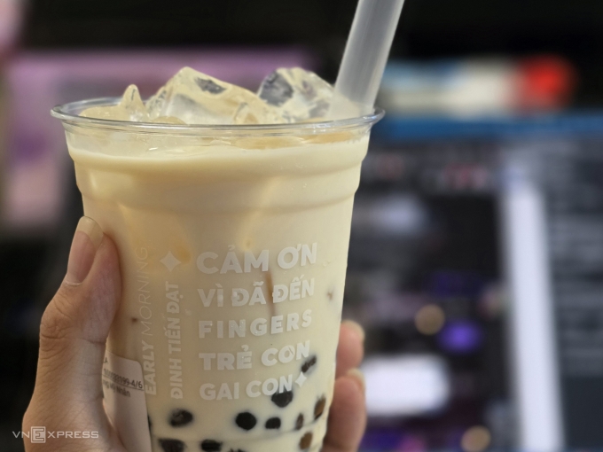 Một nhân viên văn phòng đang cầm trên tay ly trà sữa. Ảnh: Tất Đạt